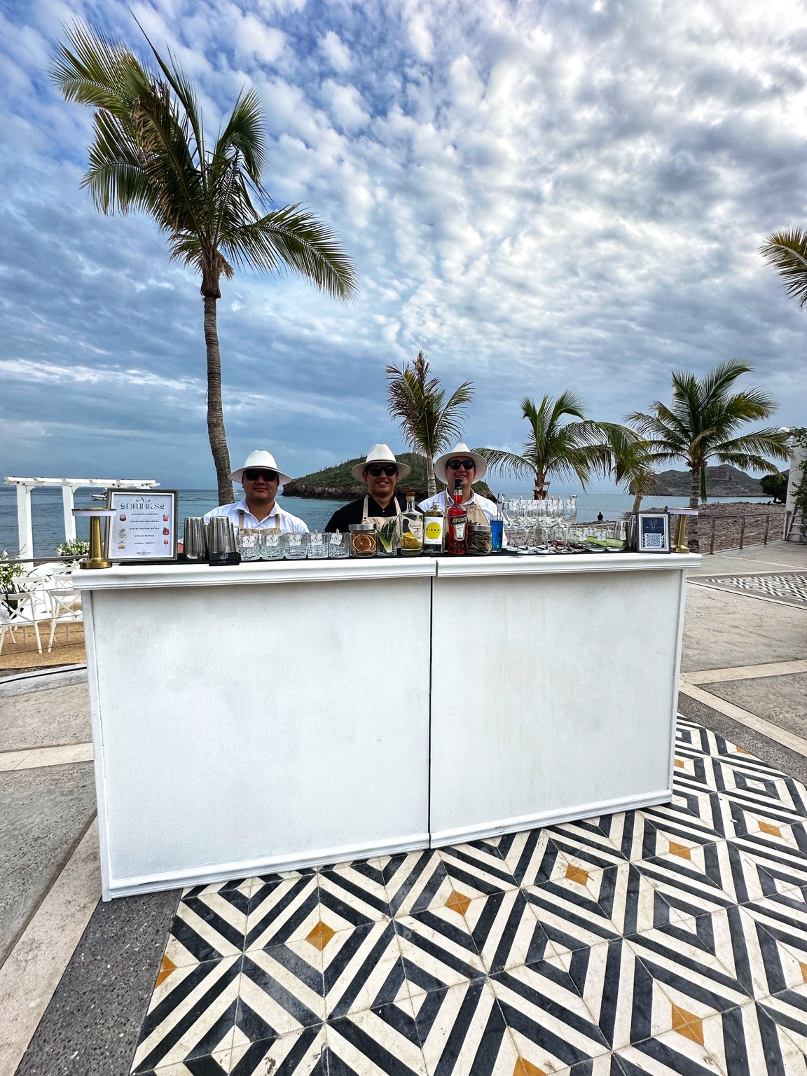 Equipo Son Drinks detrás de la barra frente al mar
