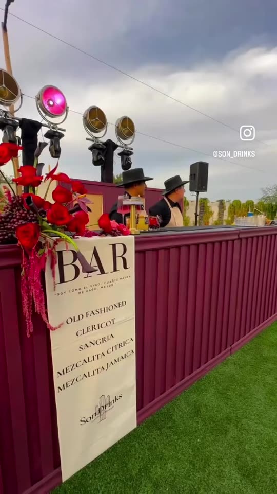 Barra color vino con flores e iluminación decorativa de Son Drinks en un evento
